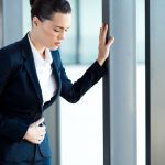 Woman having stomach ache in office