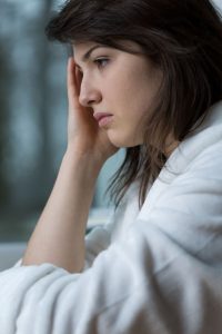 Close-up of sad woman having terrible headache