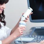 female doctor squeezing special gel from tube to scan